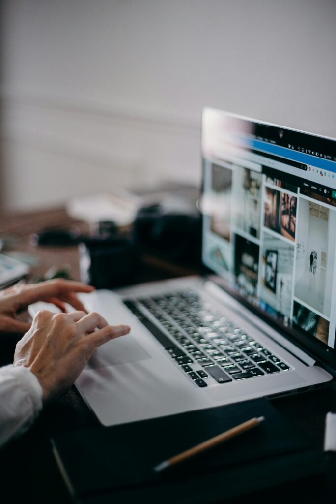 Mains sur le clavier d’un ordinateur portable affichant un site internet